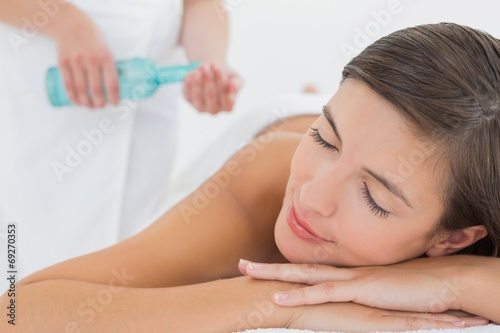 Attractive woman getting massage oil on her back