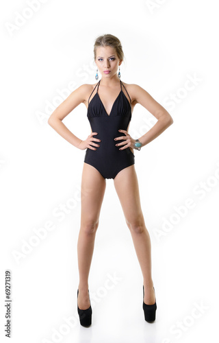 Sexy young woman posing in a black swimsuit full length isolated
