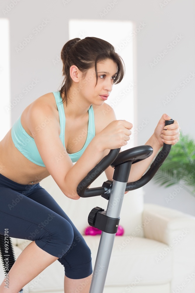 Fit brunette working out on exercise bike Fit brunette working out on exercise bike