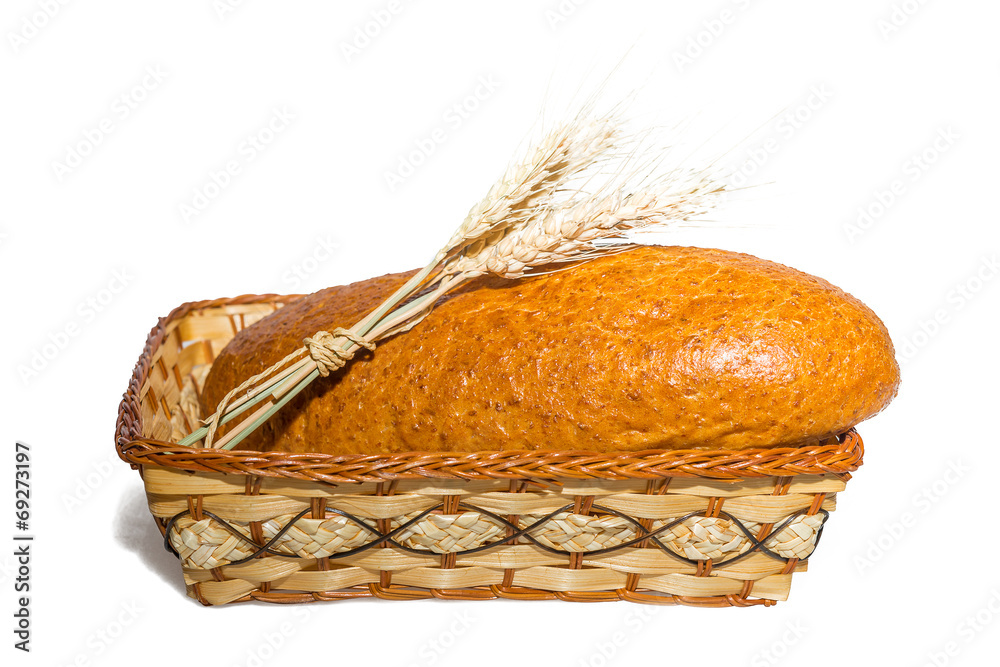 loaf in a basket with ears of wheat on a white background