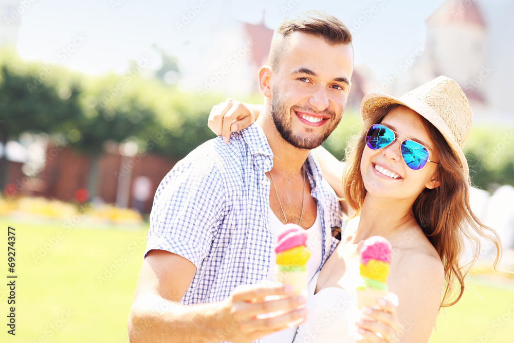 Joyful couple eating ice-cream cones