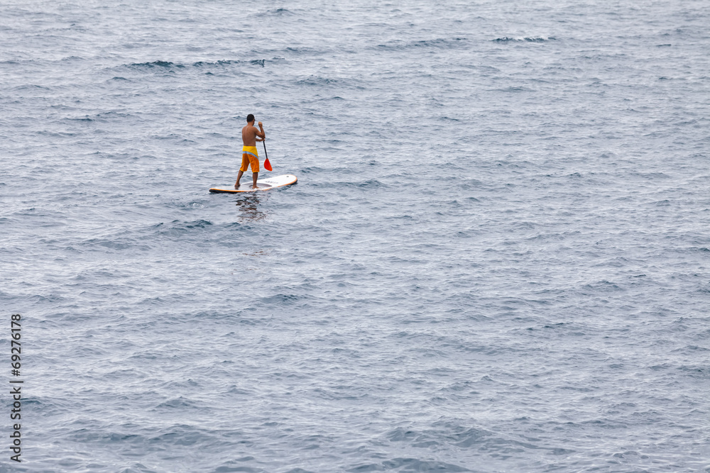 Man floating on a Board in the ocean Man floating on a Board in the ocean
