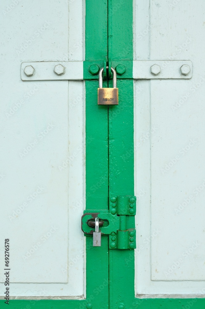 Old Brass Padlock on Wooden Green Gate Old Brass Padlock on Wooden Green Gate