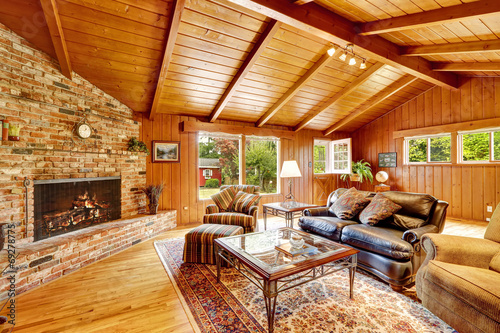 Photo Luxury log cabin house interior. Living room with fireplace and