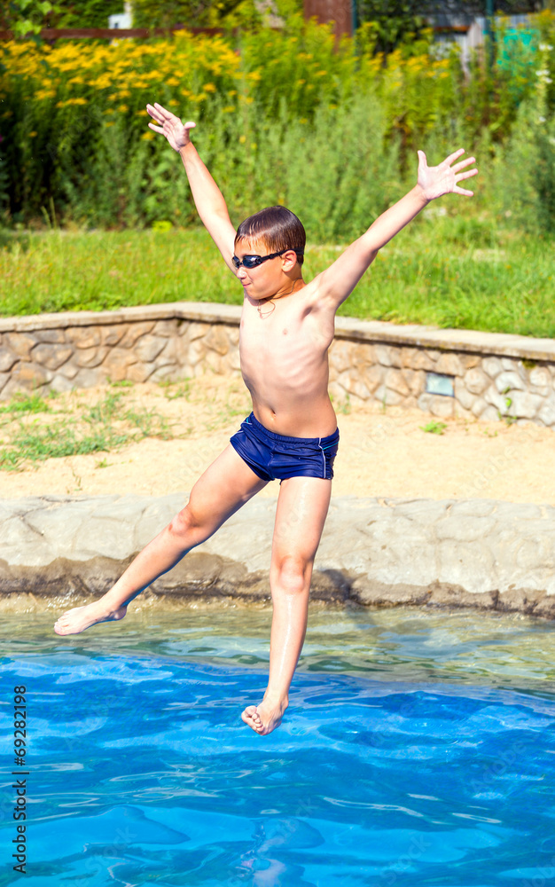 Boy jumping into a swimming pool