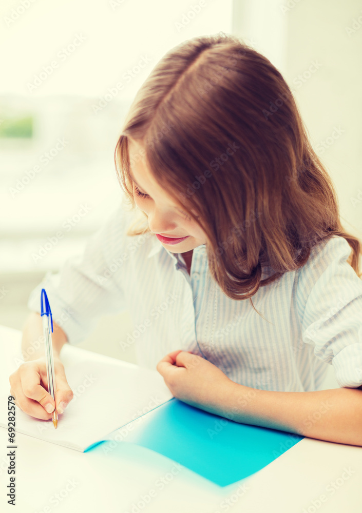 student girl writing in notebook at school student girl writing in notebook at school