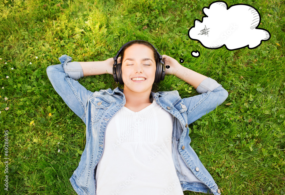 smiling young girl in headphones lying on grass smiling young girl in headphones lying on grass