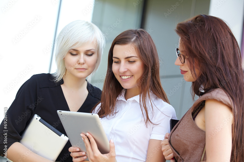 a group of businesswomеn from tablets on the street a group of businesswomеn from tablets on the street