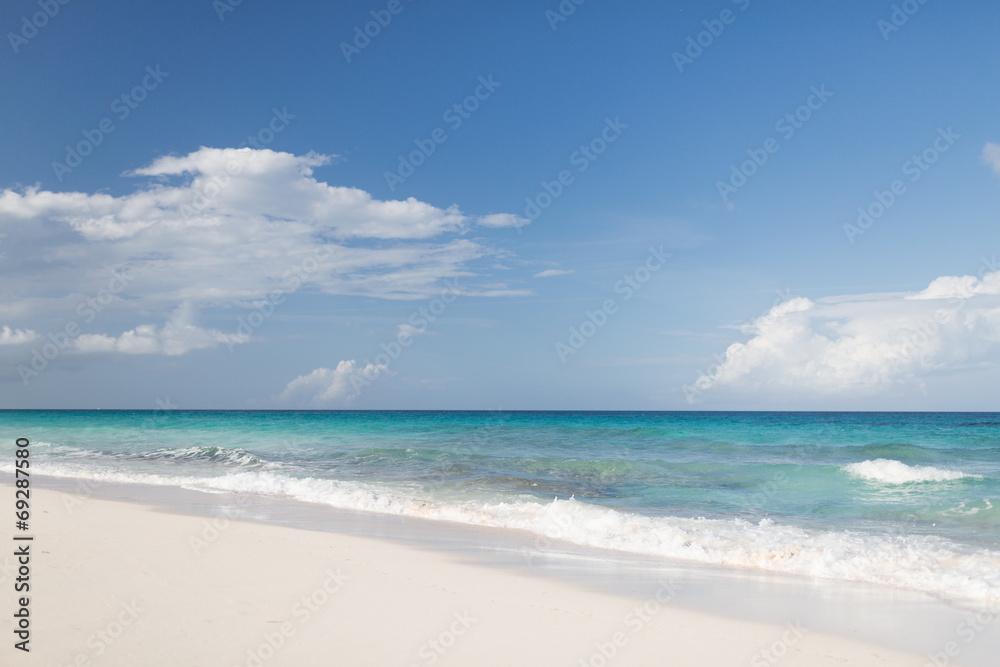 blue sea or ocean, white sand and sky with clouds