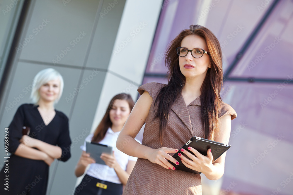 a group of businesswomеn from tablets on the street a group of businesswomеn from tablets on the street