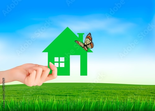 The house in hand on green natural background. Vector.