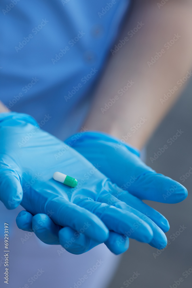 Fototapeta premium female doctor holding medicine capsules