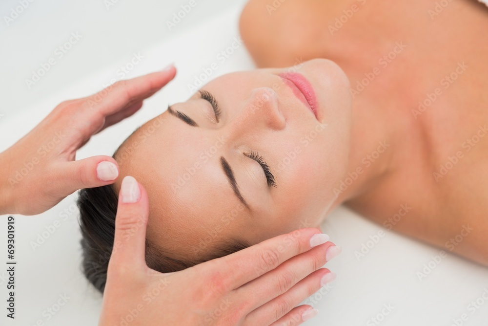 Peaceful brunette getting reiki therapy