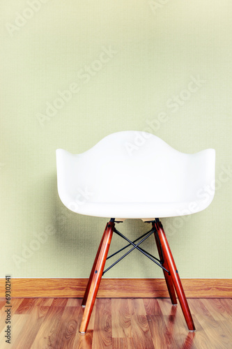 Chair in empty room against a green wall with copy-space