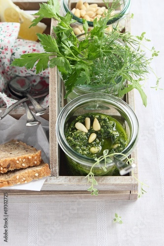Fresh delicious homemade green herbs pesto in glass jar