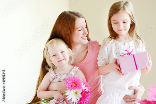Mother and he daughters giving a gift