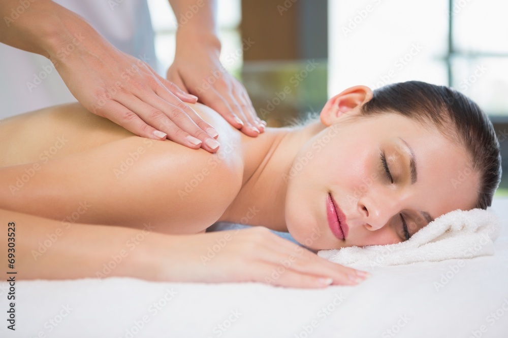 Attractive young woman receiving shoulder massage at spa center Attractive young woman receiving shoulder massage at spa center