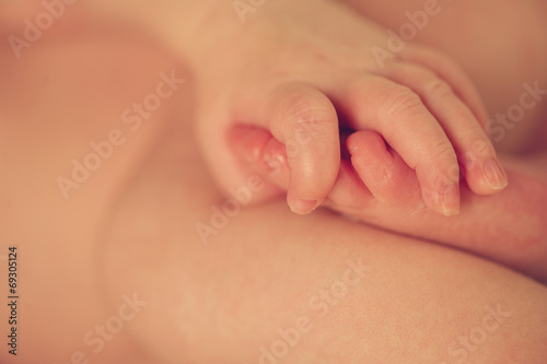 Small delicate little foot and hand of newborn