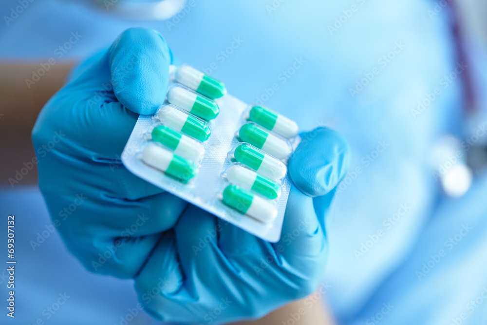 female doctor holding medicine capsules