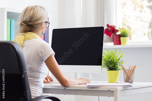 Young creative woman working with computer in the office