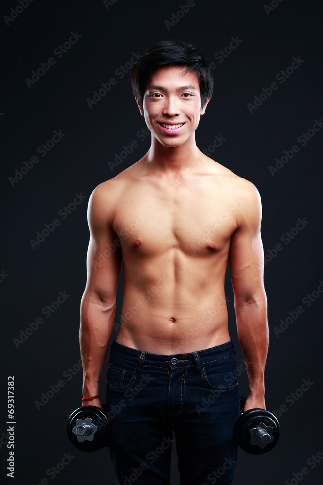 Happy asian man working out with dumbbells on black backgroung Happy asian man working out with dumbbells on black backgroung