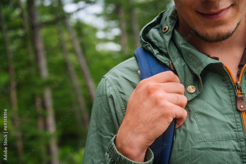 Hiker man with backpack in summer forest, close-up 