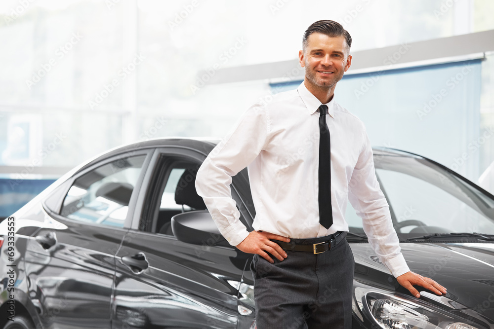 Salesman standing in car retail store. Car Showroom. Salesman standing in car retail store. Car Showroom.