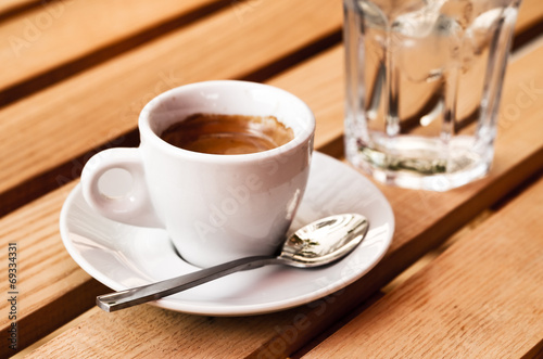 White espresso cup and glass of cold water