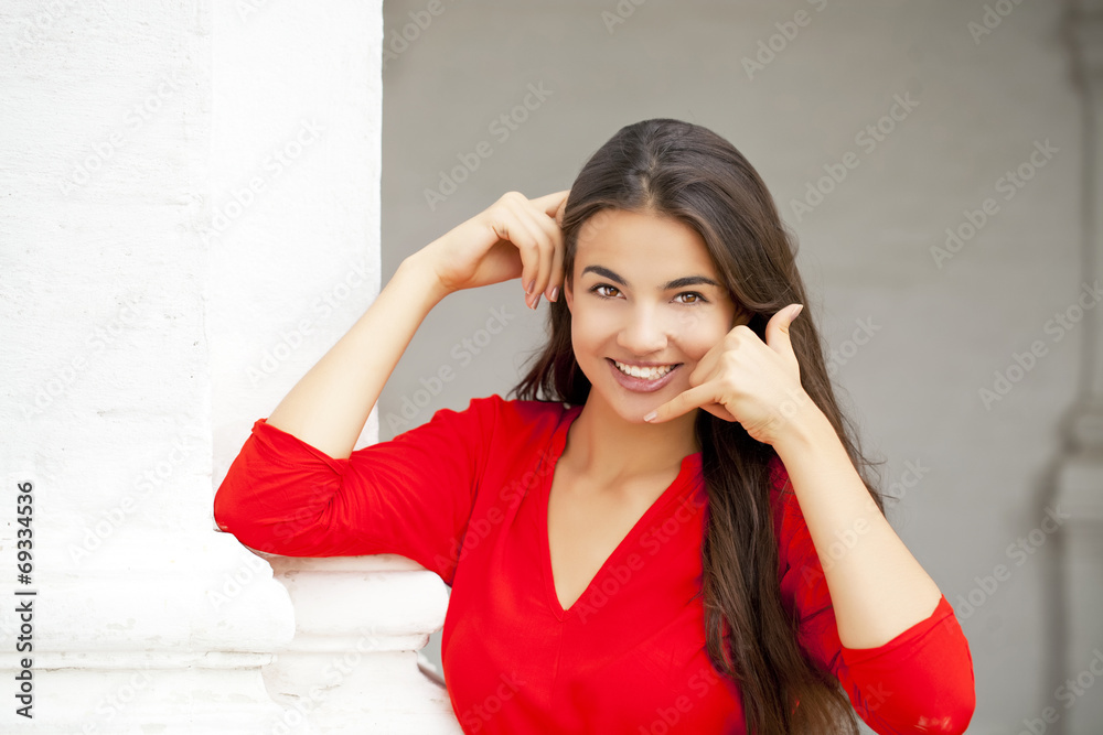 Beautiful woman making a call me gesture Beautiful woman making a call me gesture