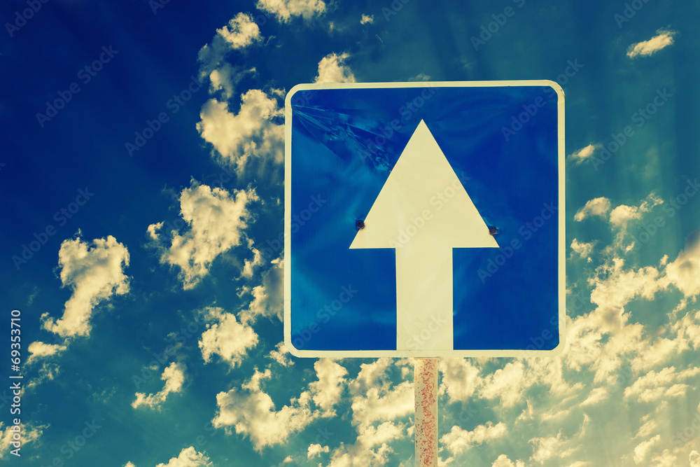 Toned image of directional road sign outdoors against sky Toned image of directional road sign outdoors against sky