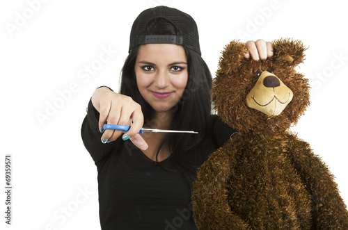 Beautiful young brunette ready to cut teddy bear with scissors photo