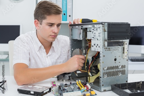 Wallpaper Mural Young technician working on broken computer Torontodigital.ca