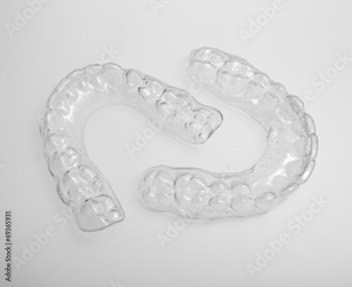 Translucent upper and lower essix retainers on a gray background
