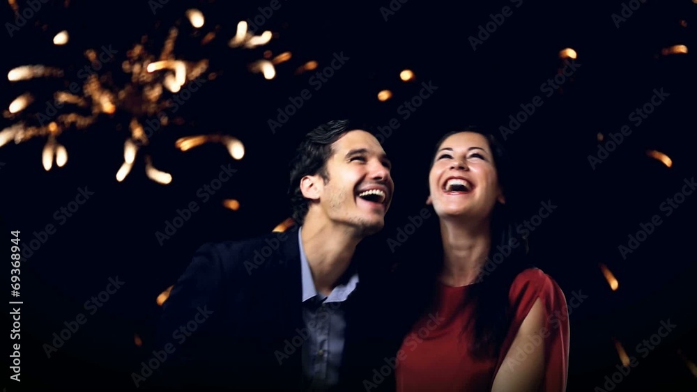 young couple enjoying new year's eve fireworks young couple enjoying new year's eve fireworks