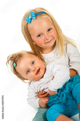 Preschool girl holding infant girl
