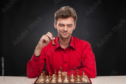 Young casual man sitting over chess.