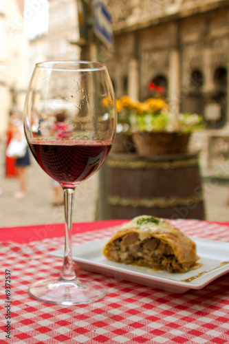 glass of red wine and a tasty food on a table outdoors