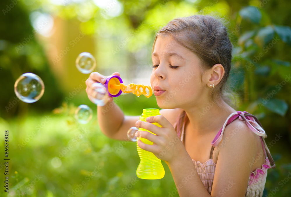 Little girl is blowing a soap bubbles Little girl is blowing a soap bubbles