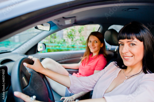 Two young and beautiful woman sitting in the car