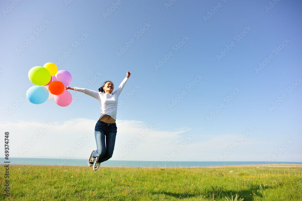 young asian woman on green grassland with colored balloons young asian woman on green grassland with colored balloons