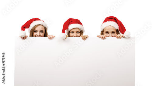 Young women in santa hats © Halfpoint