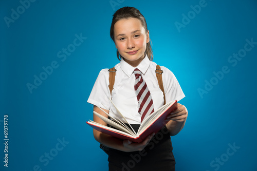 Schoolgirl with a lovely smile holding a book