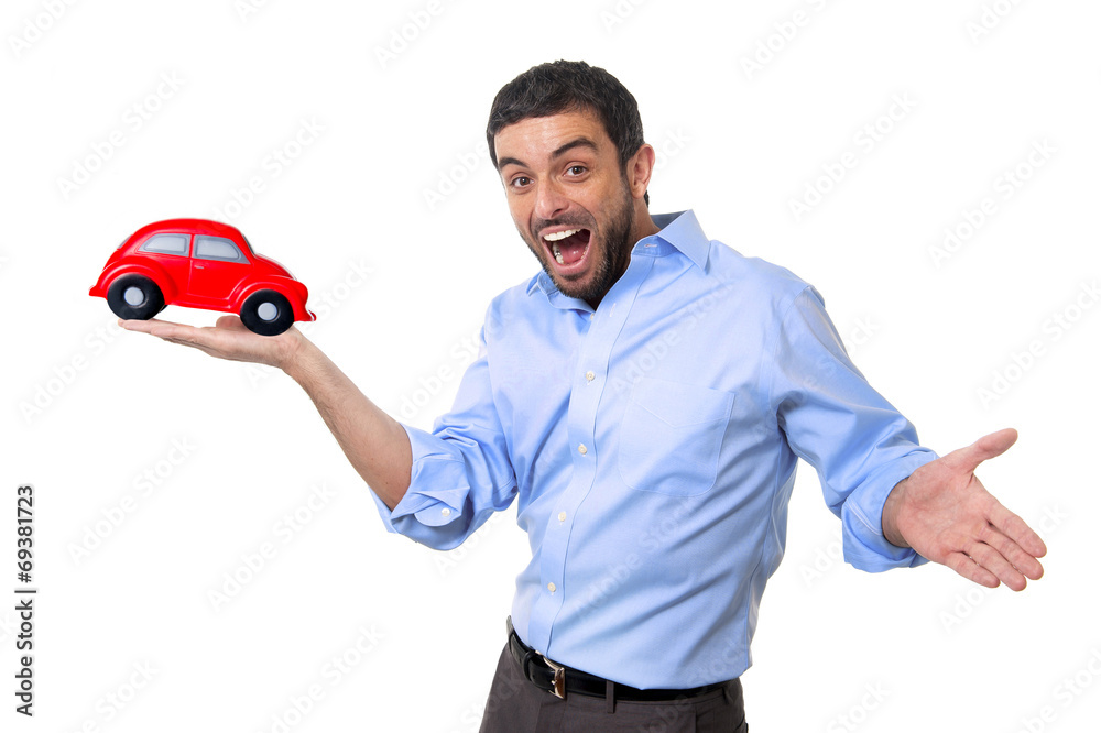 young happy attractive man pointing big red toy car on his hand
