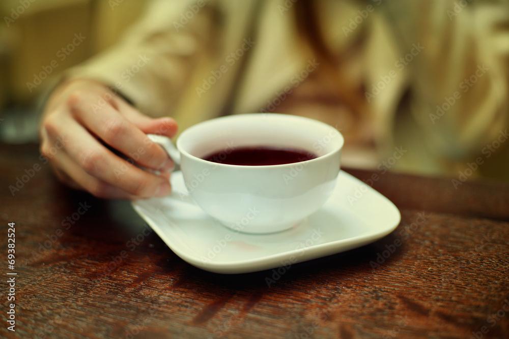 woman hands with coffee cup on a wood table at the cafe woman hands with coffee cup on a wood table at the cafe