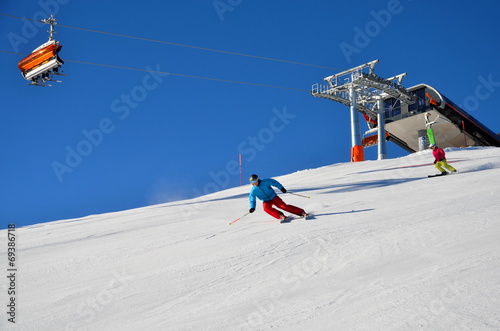Skifahrer auf Piste und Sessellift