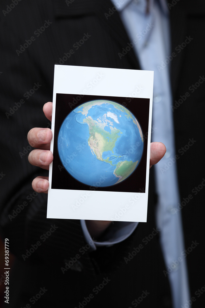Businessman holding a photo of the Earth in his hand Businessman holding a photo of the Earth in his hand