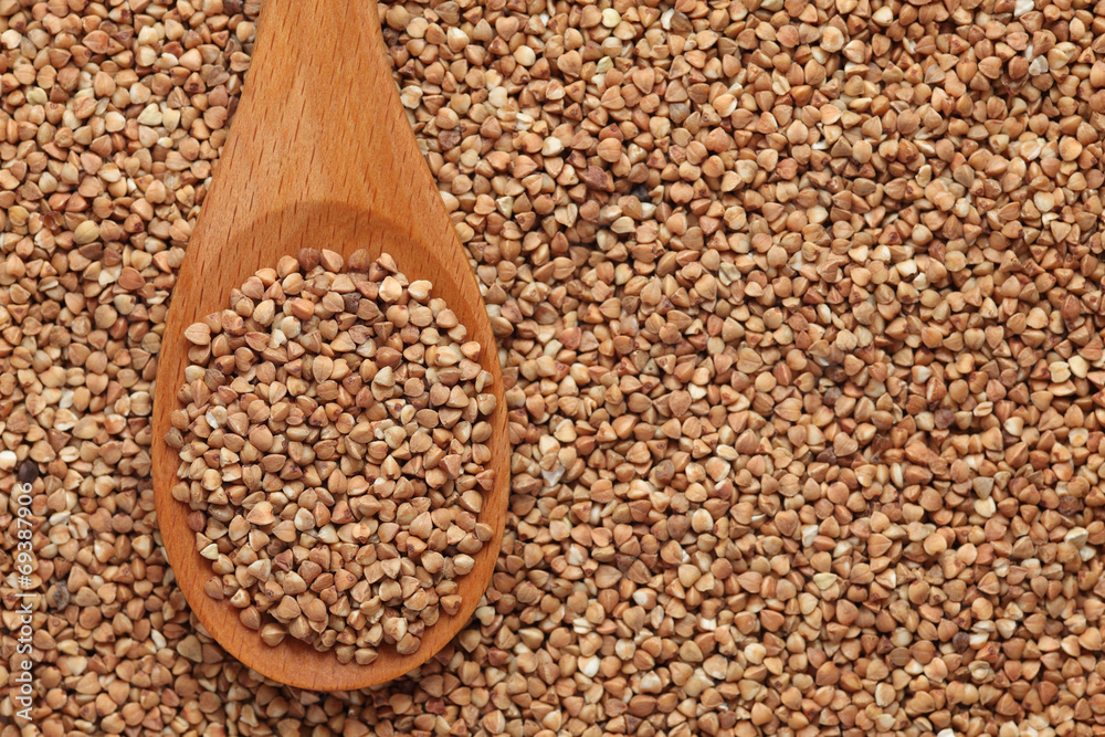Obraz premium Buckwheat in a wooden spoon