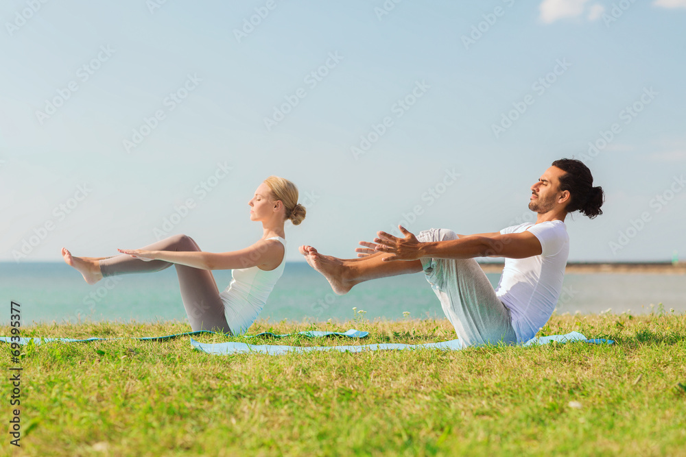 smiling couple making yoga exercises outdoors smiling couple making yoga exercises outdoors
