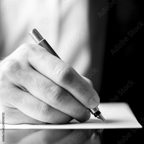Male hand holding a fountain pen as though writing
