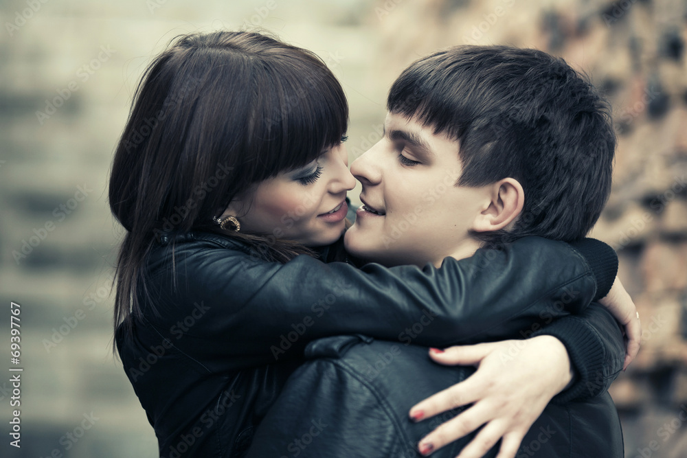 Happy young couple in love at the brick wall